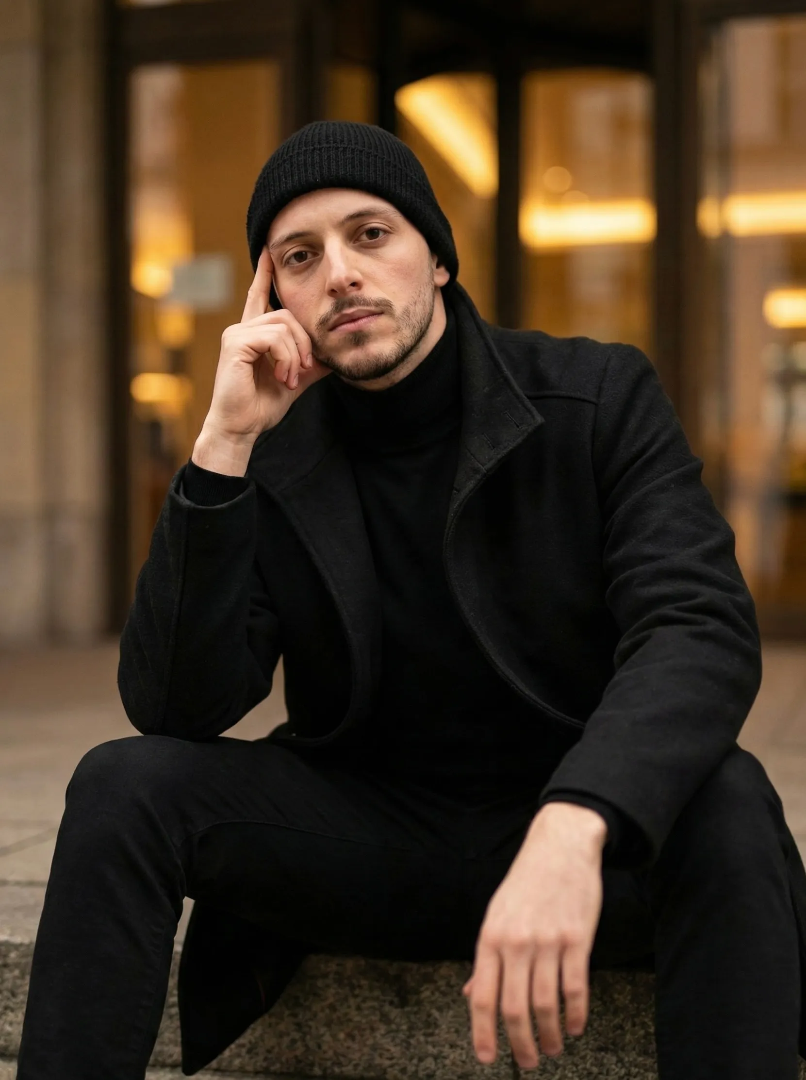 Ivan Salloum sitting outside a warm-lit building in Dresden